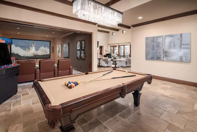 a living room with furniture pool table and a wall painting