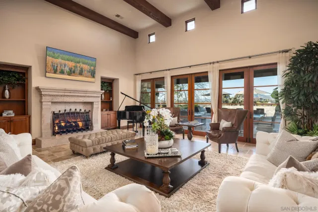 a living room with fireplace furniture and a large window
