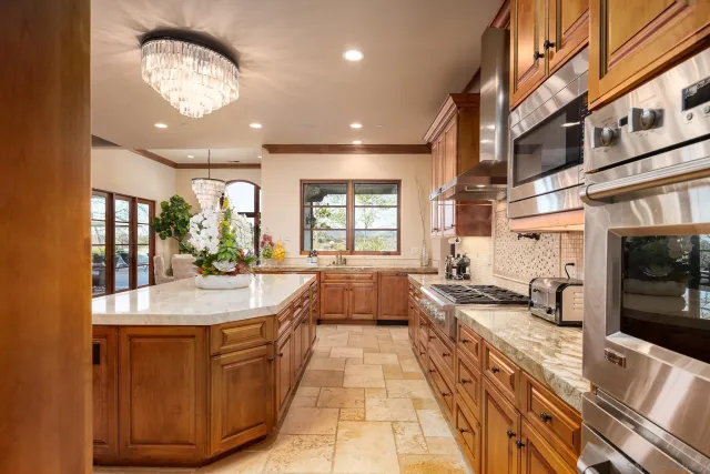 a large kitchen with kitchen island granite countertop a large counter top and stainless steel appliances