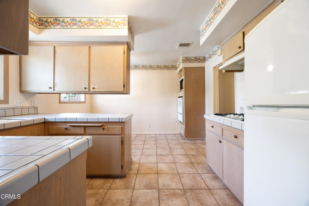 6940 Bellclaire Street Tujunga, CA 91042 - Photo 12 of 47 a kitchen with a stove a sink and a refrigerator