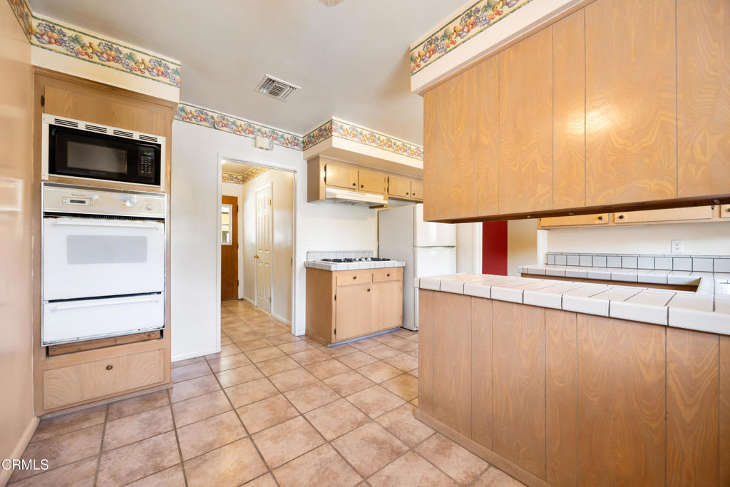 6940 Bellclaire Street Tujunga, CA 91042 - Photo 15 of 47 a kitchen with stainless steel appliances a refrigerator and a stove top oven