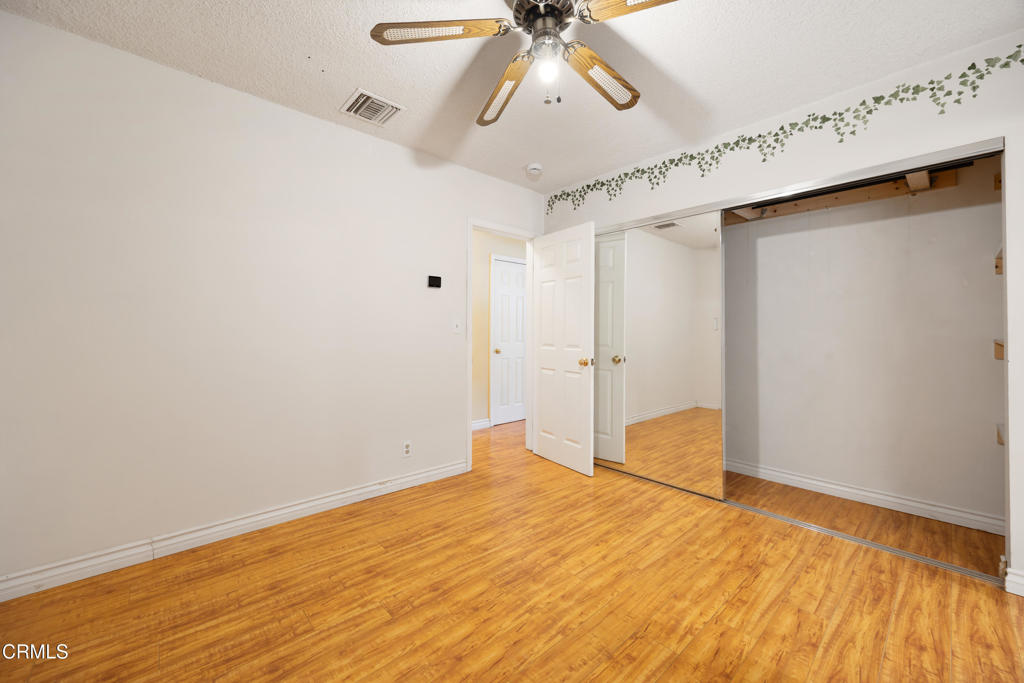 6940 Bellclaire Street Tujunga, CA 91042 - Photo 16 of 47 a bedroom with a bed and a chandelier