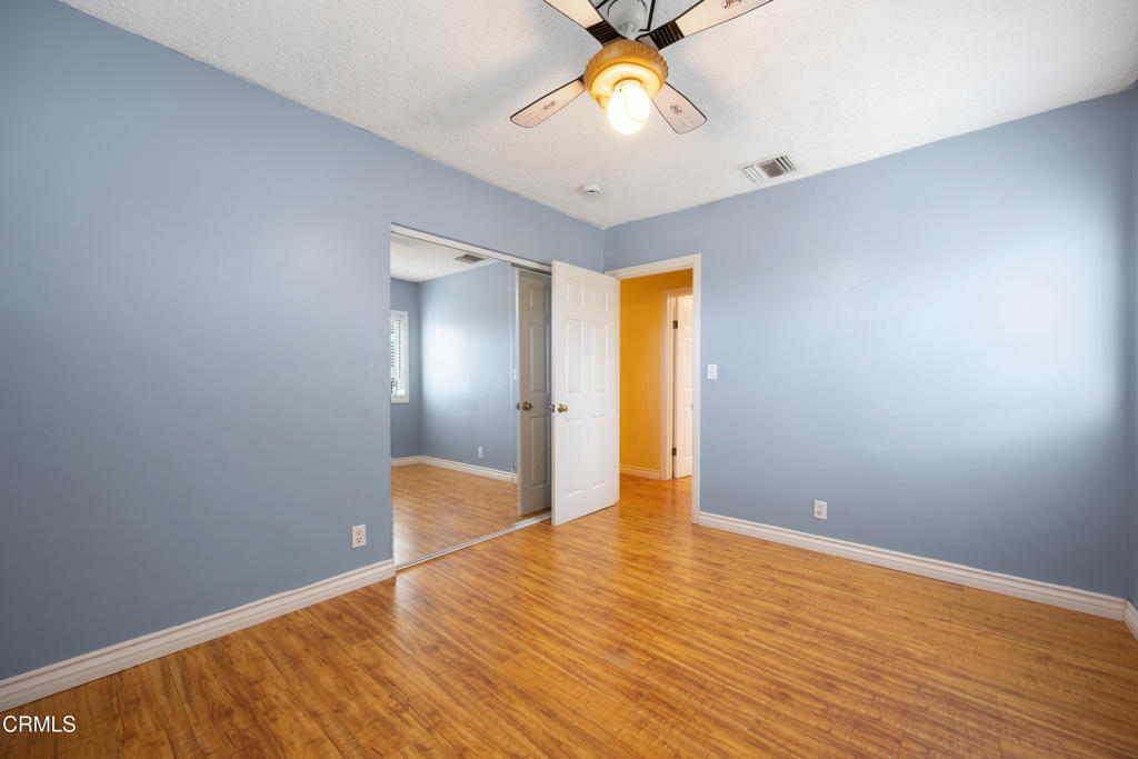 6940 Bellclaire Street Tujunga, CA 91042 - Photo 21 of 47 a view of an empty room with wooden floor and a ceiling fan