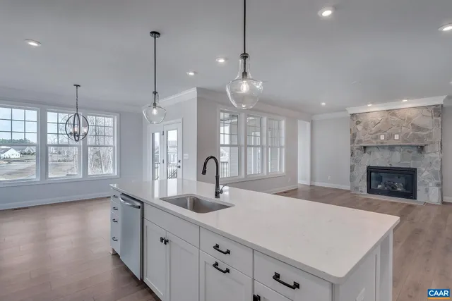 a kitchen with a sink chandelier and a fireplace