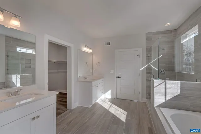 a spacious bathroom with a shower sink and mirror