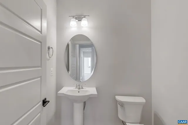 a bathroom with a toilet a sink and mirror
