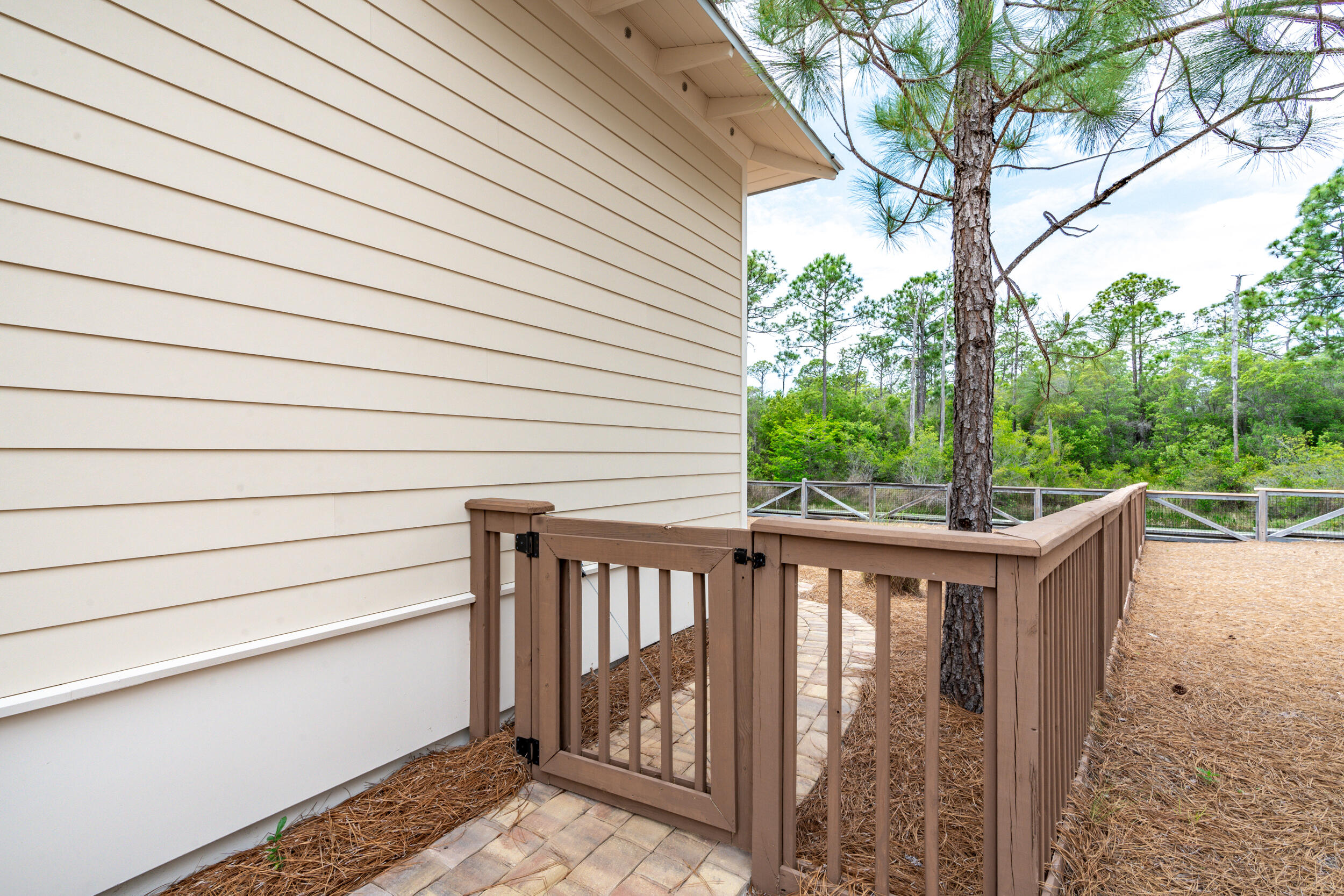 345 Flatwoods Forest Loop Santa Rosa Beach, FL 32459 - Photo 44 of 62 a balcony with wooden floor and fence and a table
