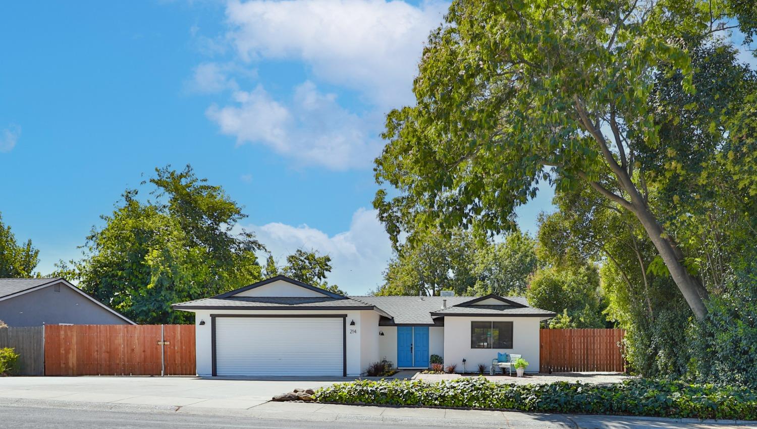 a front view of a house with a yard and trees