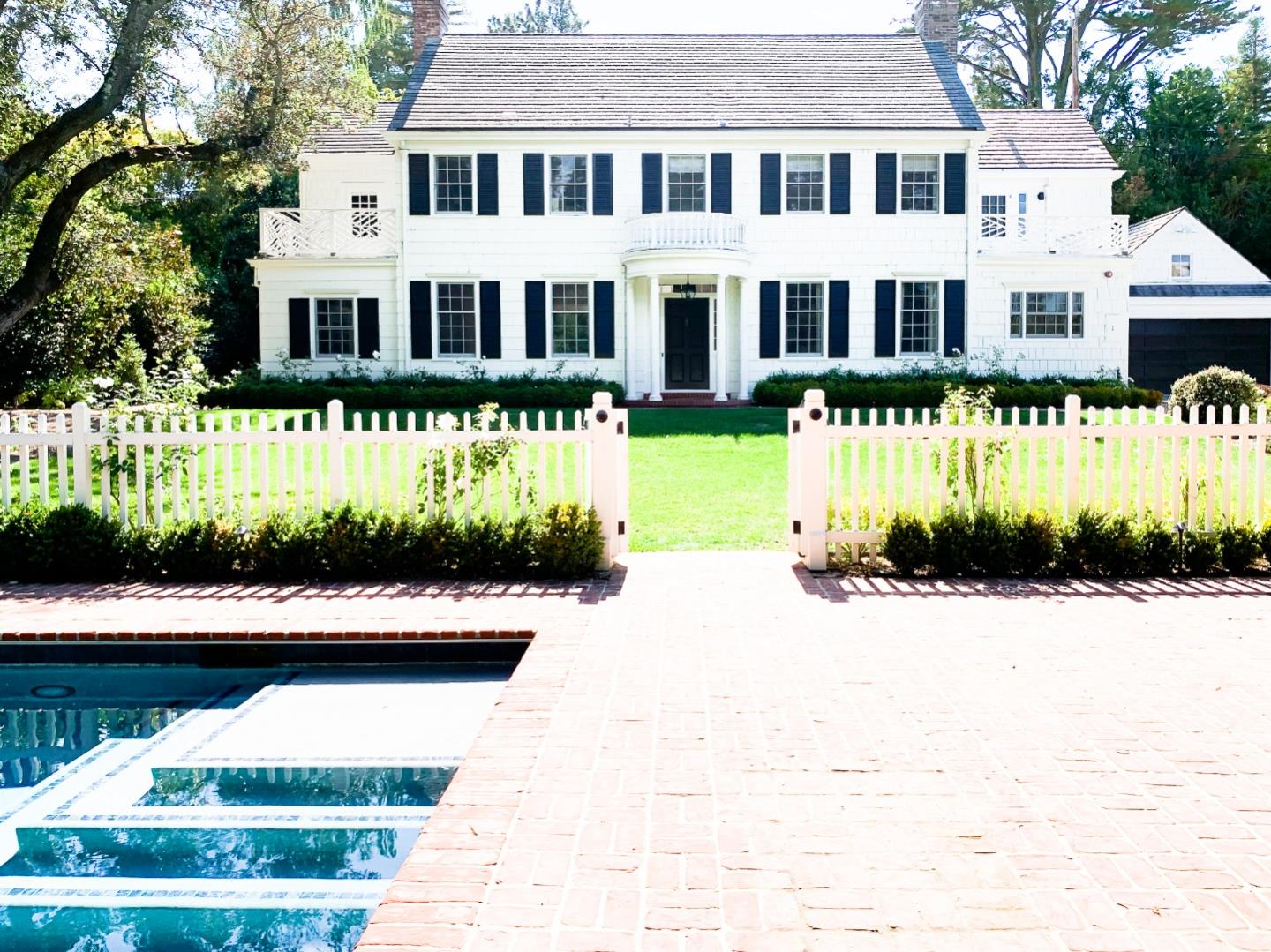 a front view of a building with a garden and plants
