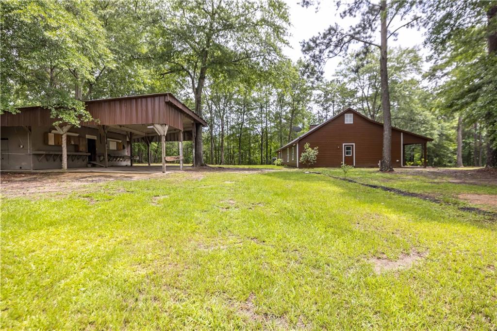 25 Gas Line Road Phenix City, AL 36870 - Photo 50 of 52 View of green lawn featuring an outbuilding, an outdoor structure, and a carport