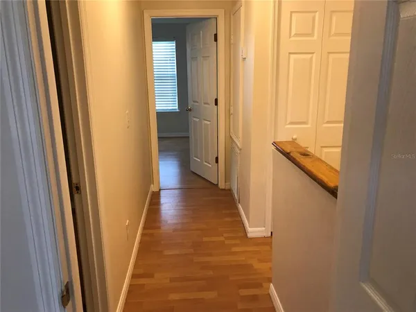 a view of a hallway with wooden floor and staircase