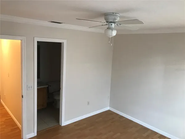 a view of a small space with wooden floor and a ceiling fan