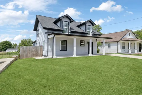 a front view of a house with a garden and yard