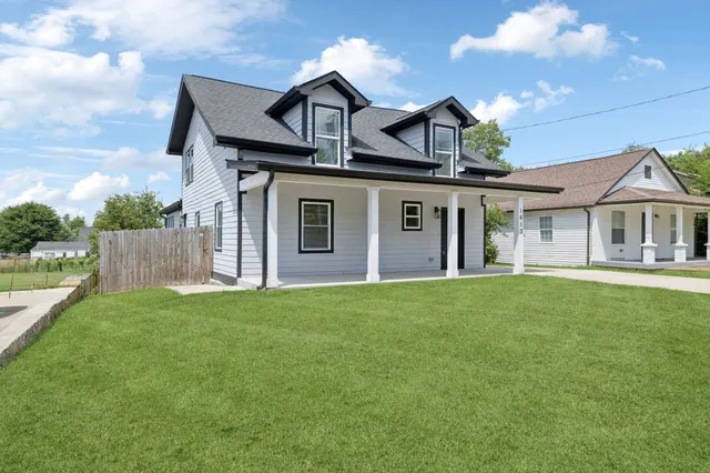 a front view of a house with a garden and yard
