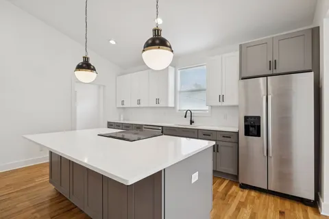 a kitchen with granite countertop a sink a counter space appliances and cabinets