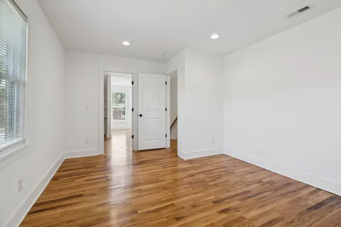 a view of an empty room with wooden floor
