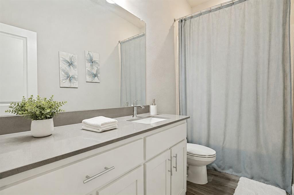 617 Mesquite Grove Road Midlothian, TX 76065 - Photo 20 of 25 White vanity with brushed nickel pulls, integrated rectangular sink, and gray stone-finish countertop