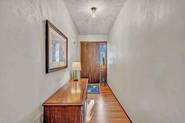 a view of a hallway with a window and a chandelier