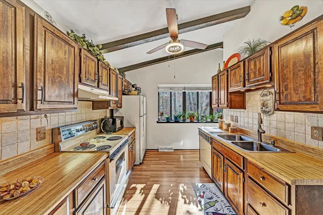 a kitchen with stainless steel appliances granite countertop a sink stove and cabinets