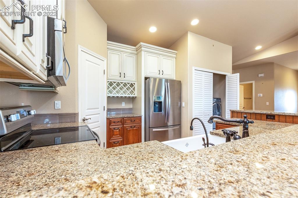 2361 Conservatory Point Colorado Springs, CO 80918 - Photo 11 of 50 a large bedroom with stainless steel appliances kitchen island granite countertop a refrigerator and a sink