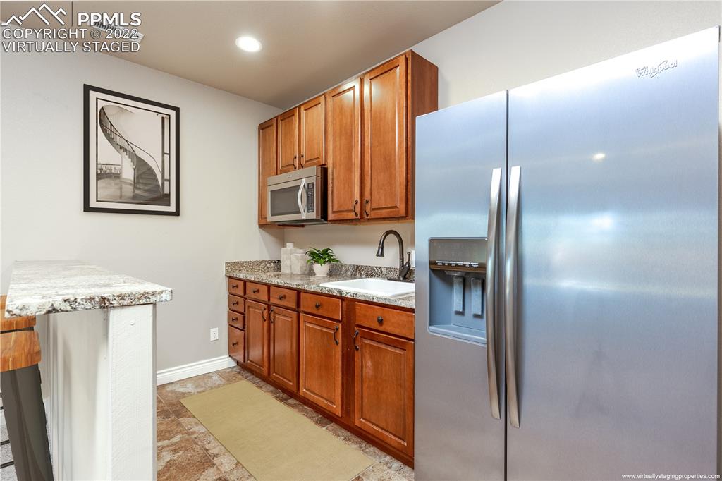 2361 Conservatory Point Colorado Springs, CO 80918 - Photo 24 of 50 a kitchen with stainless steel appliances granite countertop a refrigerator a stove and a sink