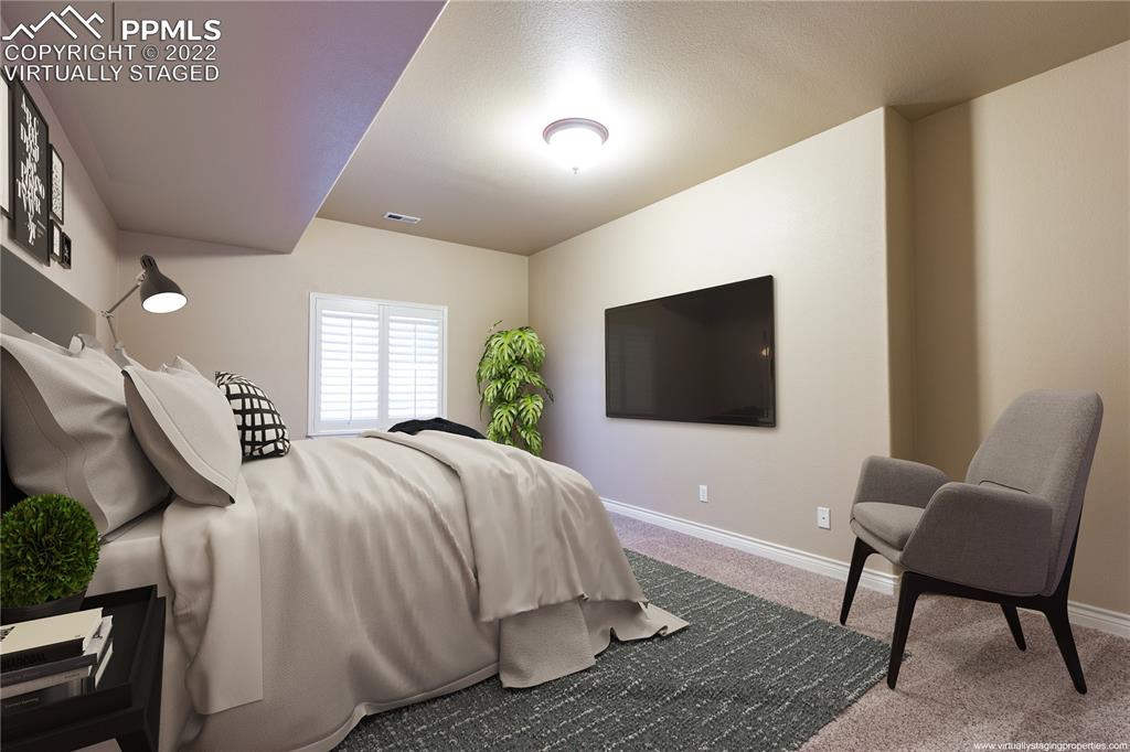 2361 Conservatory Point Colorado Springs, CO 80918 - Photo 26 of 50 a spacious bedroom with a bed and a flat screen tv