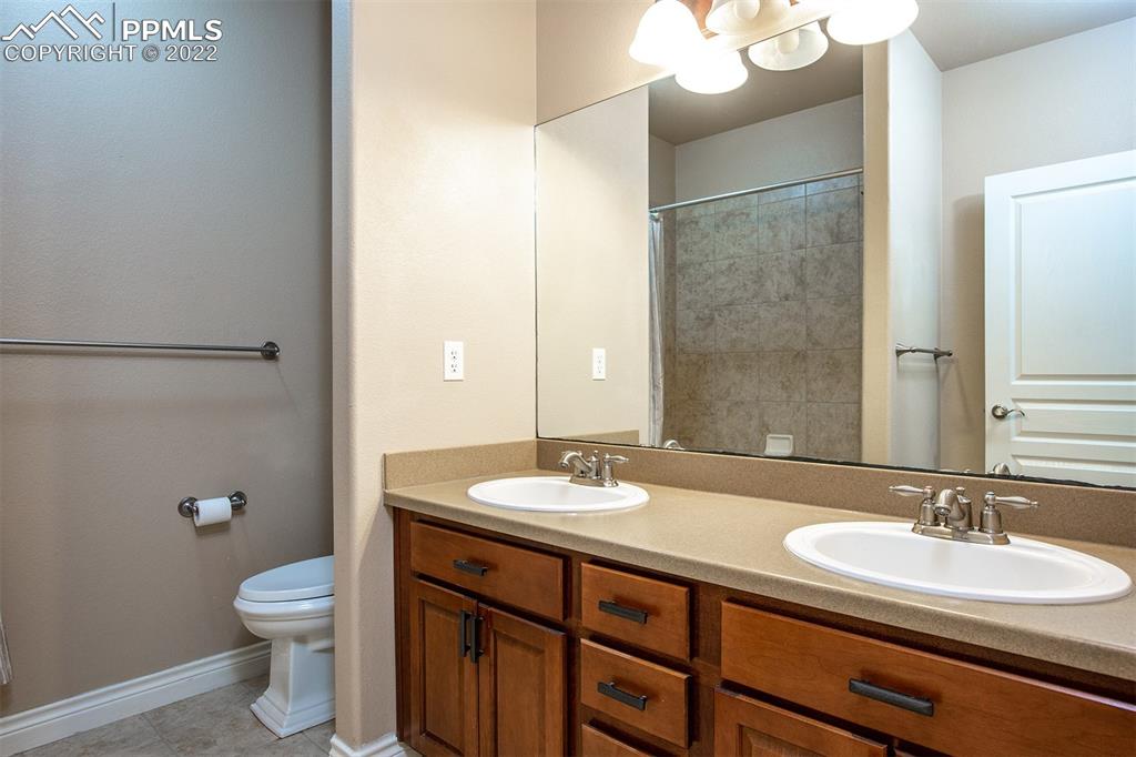 2361 Conservatory Point Colorado Springs, CO 80918 - Photo 27 of 50 a bathroom with a granite countertop toilet a sink and a mirror