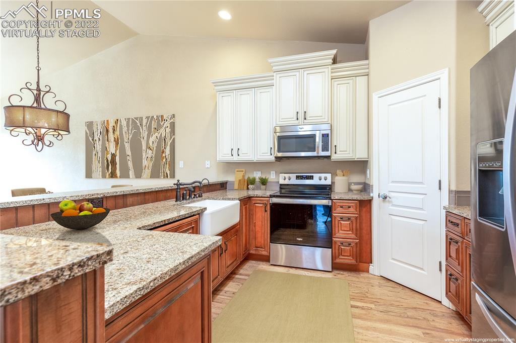 2361 Conservatory Point Colorado Springs, CO 80918 - Photo 10 of 50 a kitchen with stainless steel appliances granite countertop a stove refrigerator and a sink