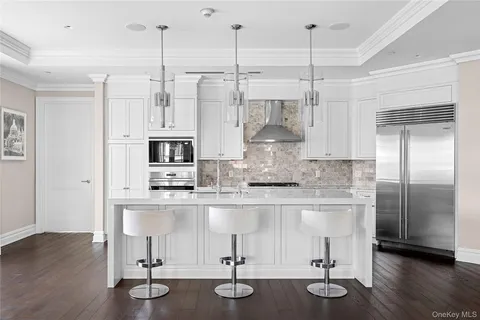 a kitchen with stainless steel appliances granite countertop a refrigerator a stove and a wooden floors