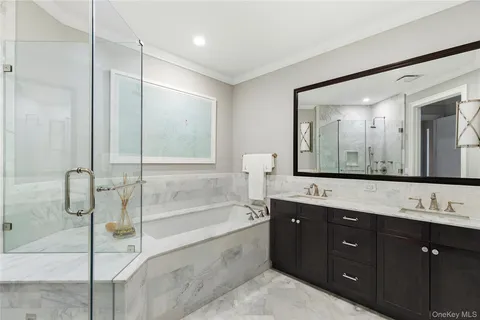 a spacious bathroom with a tub sink shower and mirror