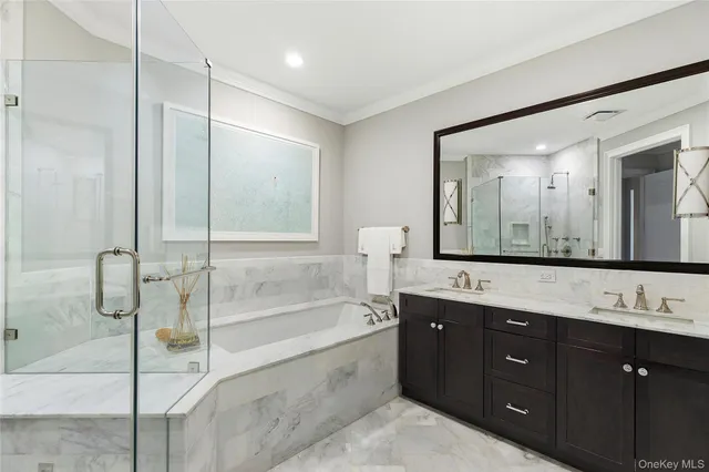 a spacious bathroom with a tub sink shower and mirror
