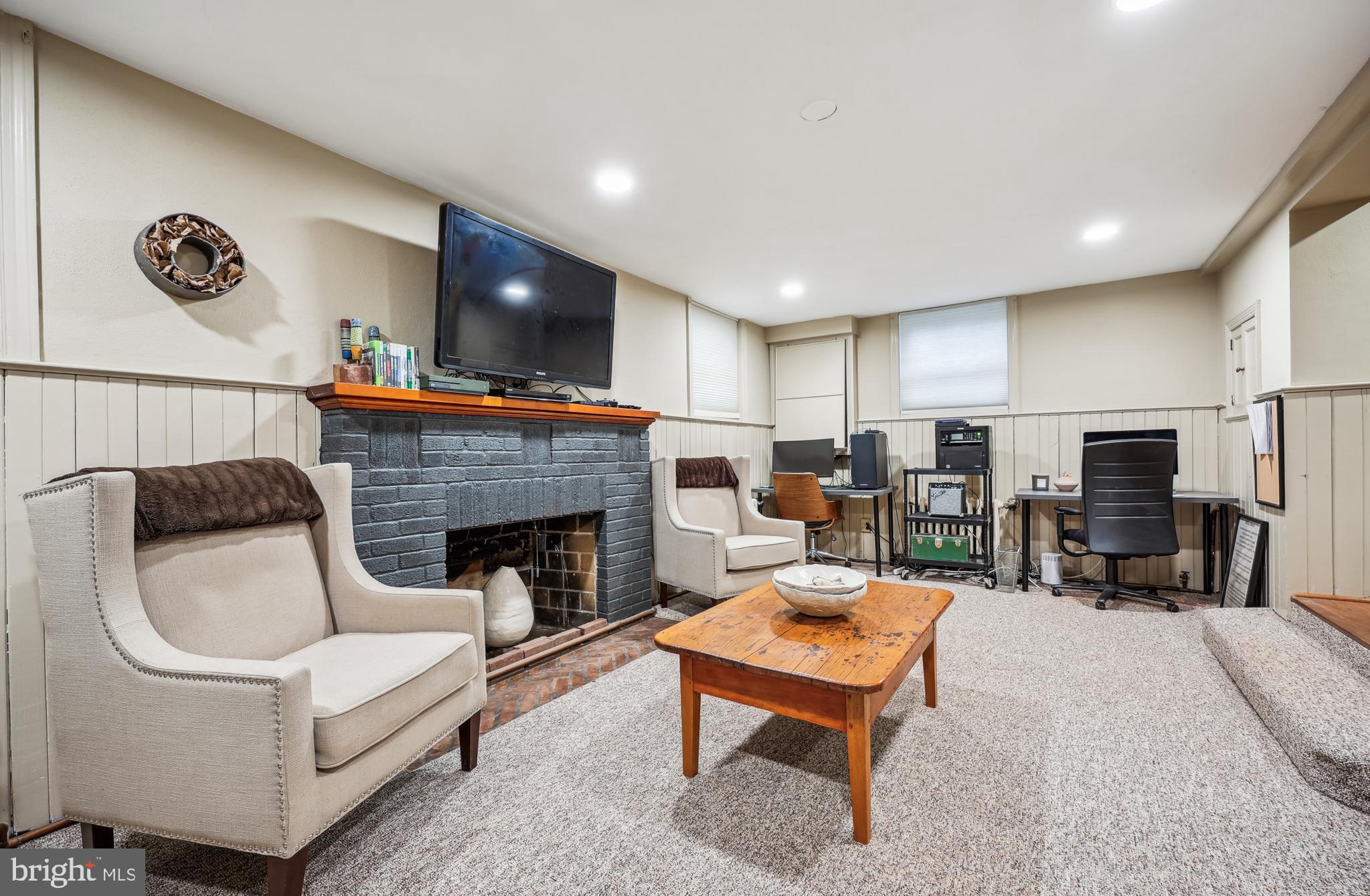 9014 Fairview Road Silver Spring, MD 20910 - Photo 62 of 94 a living room with furniture a fireplace and a flat screen tv