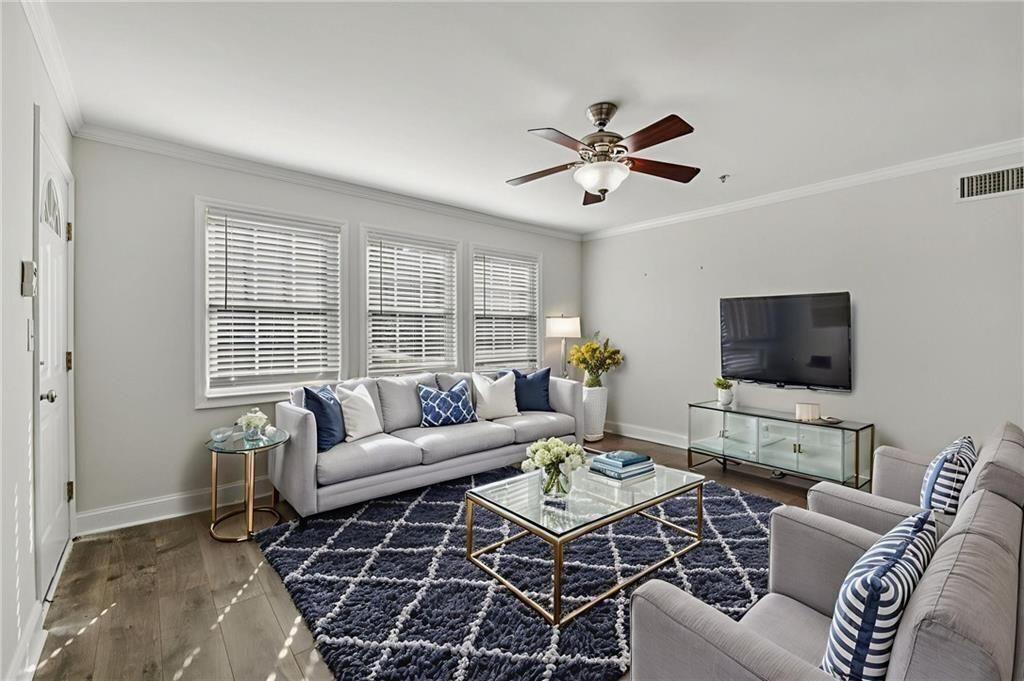 a living room with furniture a flat screen tv and a window