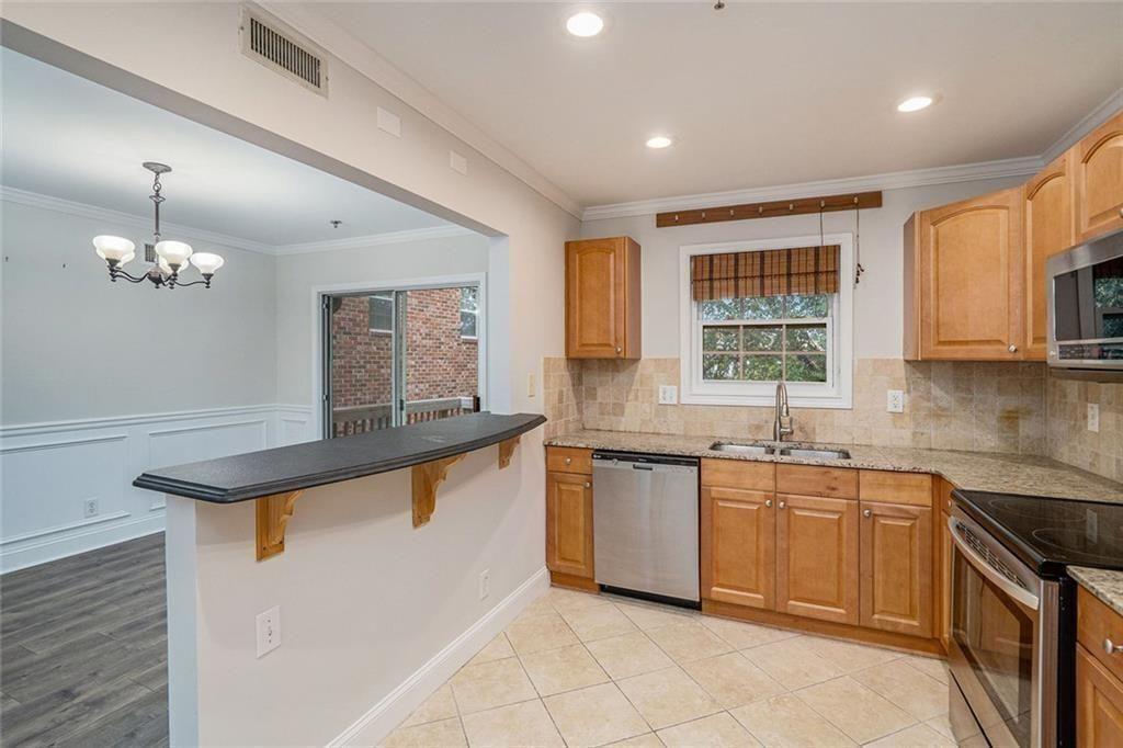 2825 Northeast Expressway, Unit F3 Atlanta, GA 30345 - Photo 15 of 45 a kitchen with stainless steel appliances granite countertop a sink a stove a counter space and cabinets