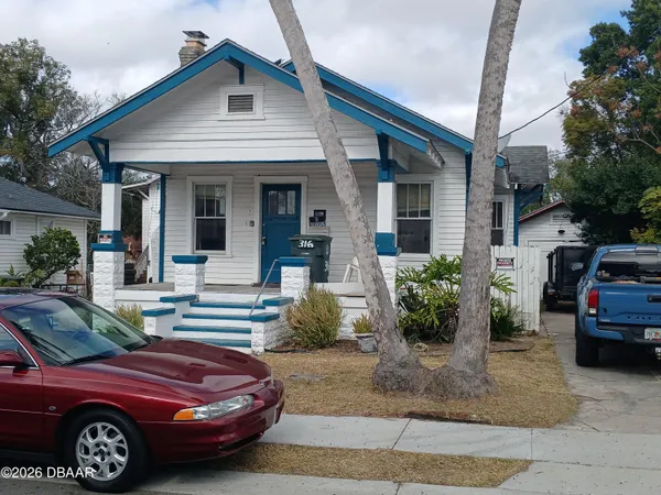 a front view of a house with cars parked