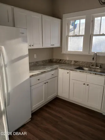 a kitchen with stainless steel appliances granite countertop a stove a sink and white cabinets