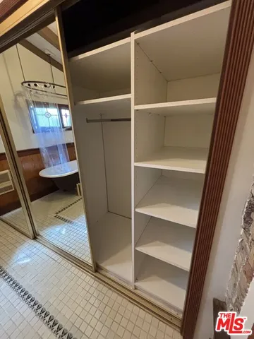 a view of walk in closet with empty racks