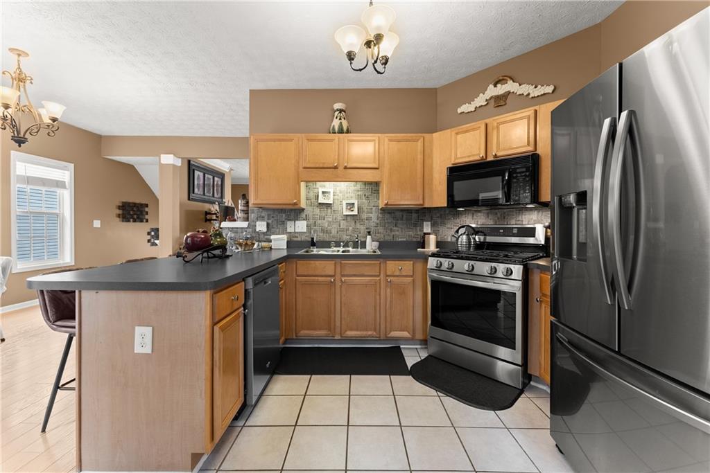 1628 Indian Way Cumming, GA 30040 - Photo 12 of 39 a kitchen with stainless steel appliances granite countertop a stove a sink and a refrigerator