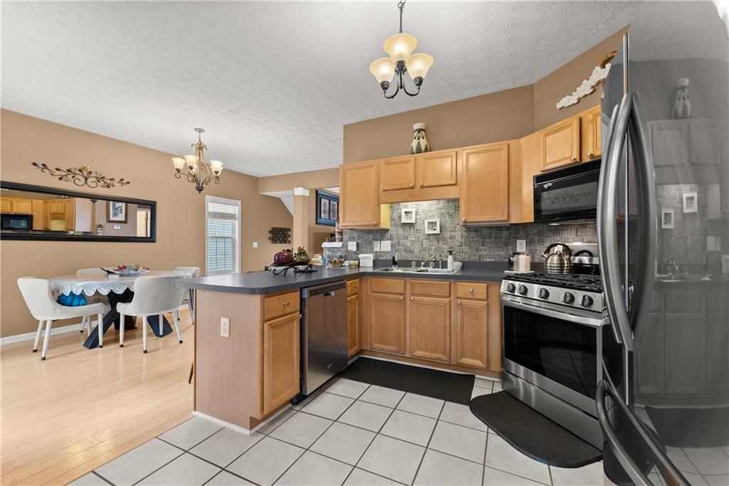1628 Indian Way Cumming, GA 30040 - Photo 14 of 39 a kitchen with stainless steel appliances granite countertop a stove and a sink