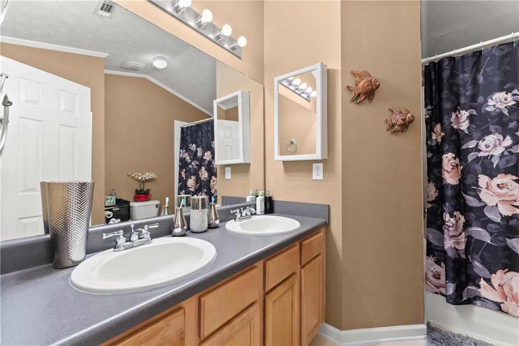 1628 Indian Way Cumming, GA 30040 - Photo 28 of 39 a bathroom with a double vanity sink and a mirror