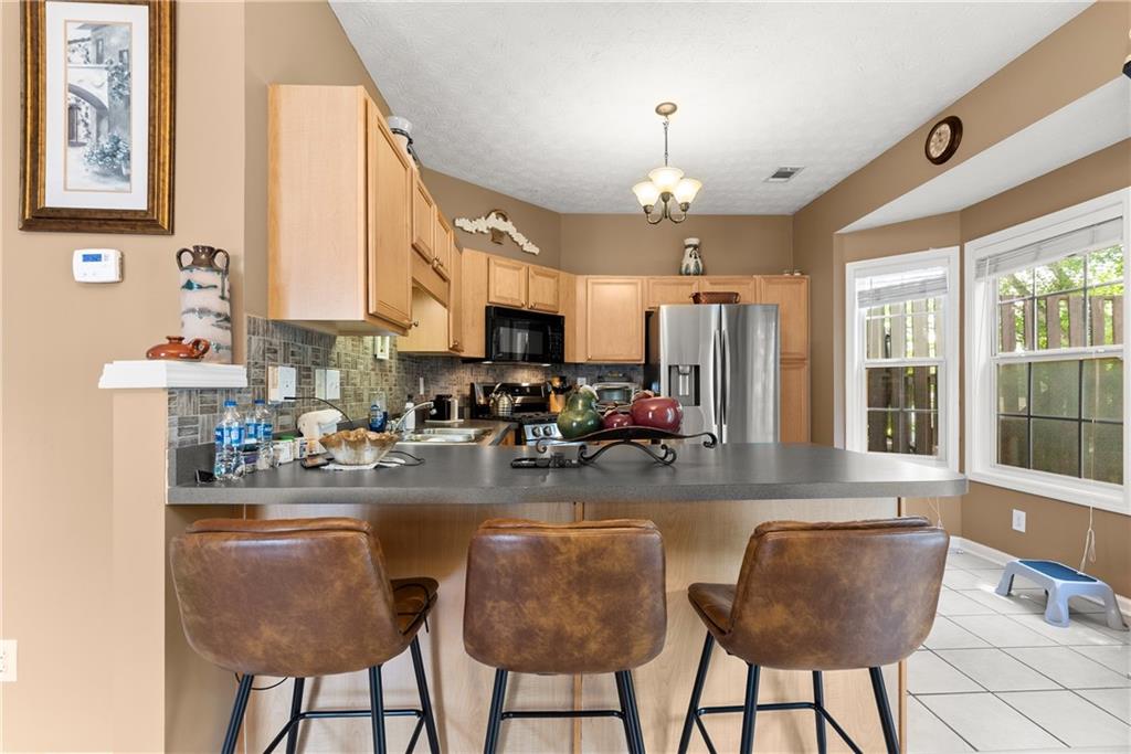 1628 Indian Way Cumming, GA 30040 - Photo 10 of 39 a kitchen with sink refrigerator dining table and chairs