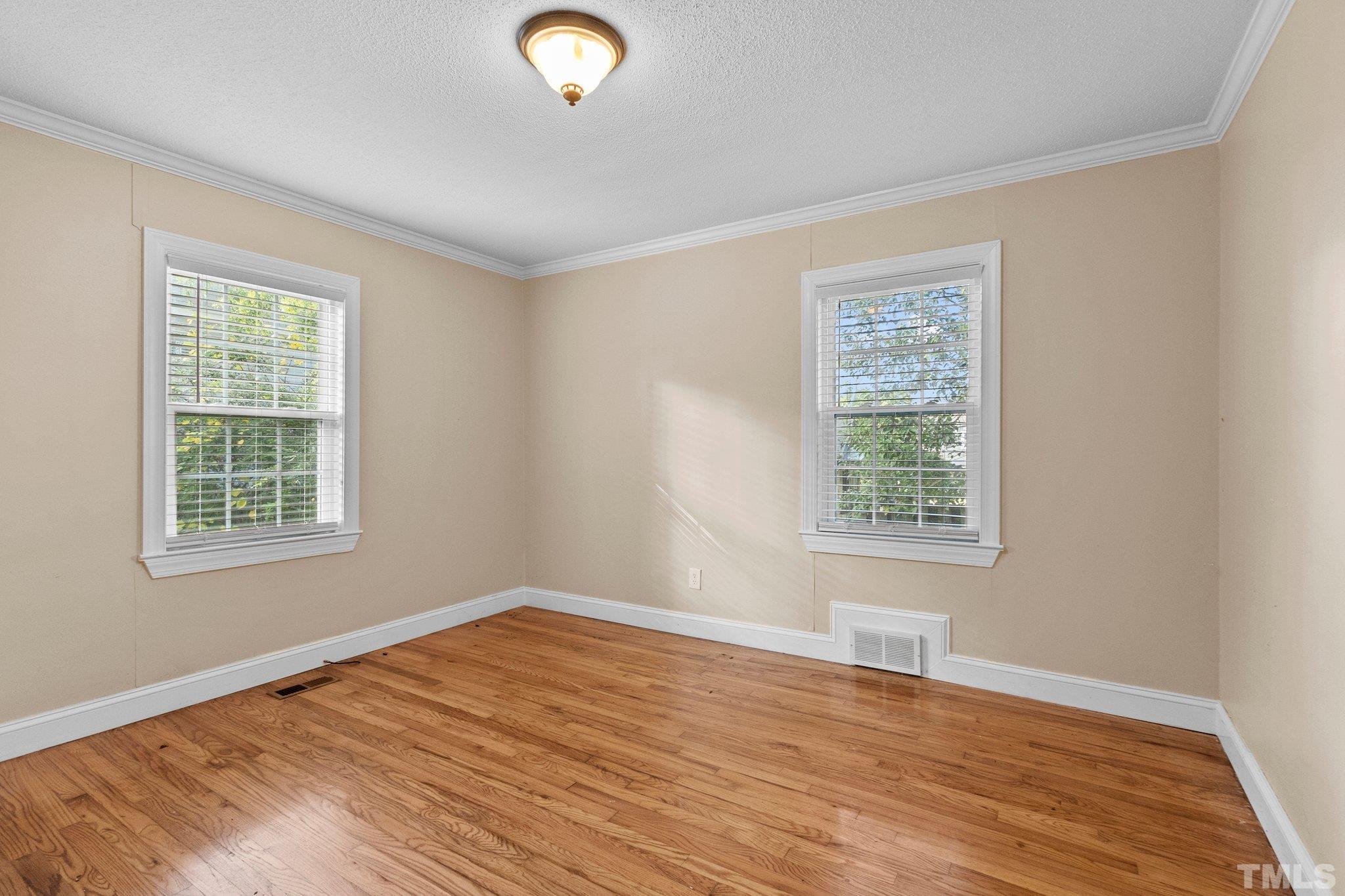 1713 Oberlin Road Raleigh, NC 27608 - Photo 14 of 34 an empty room with wooden floor and windows