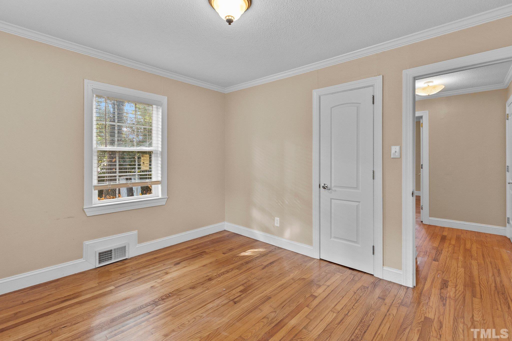 1713 Oberlin Road Raleigh, NC 27608 - Photo 15 of 34 a view of an empty room with wooden floor and a window