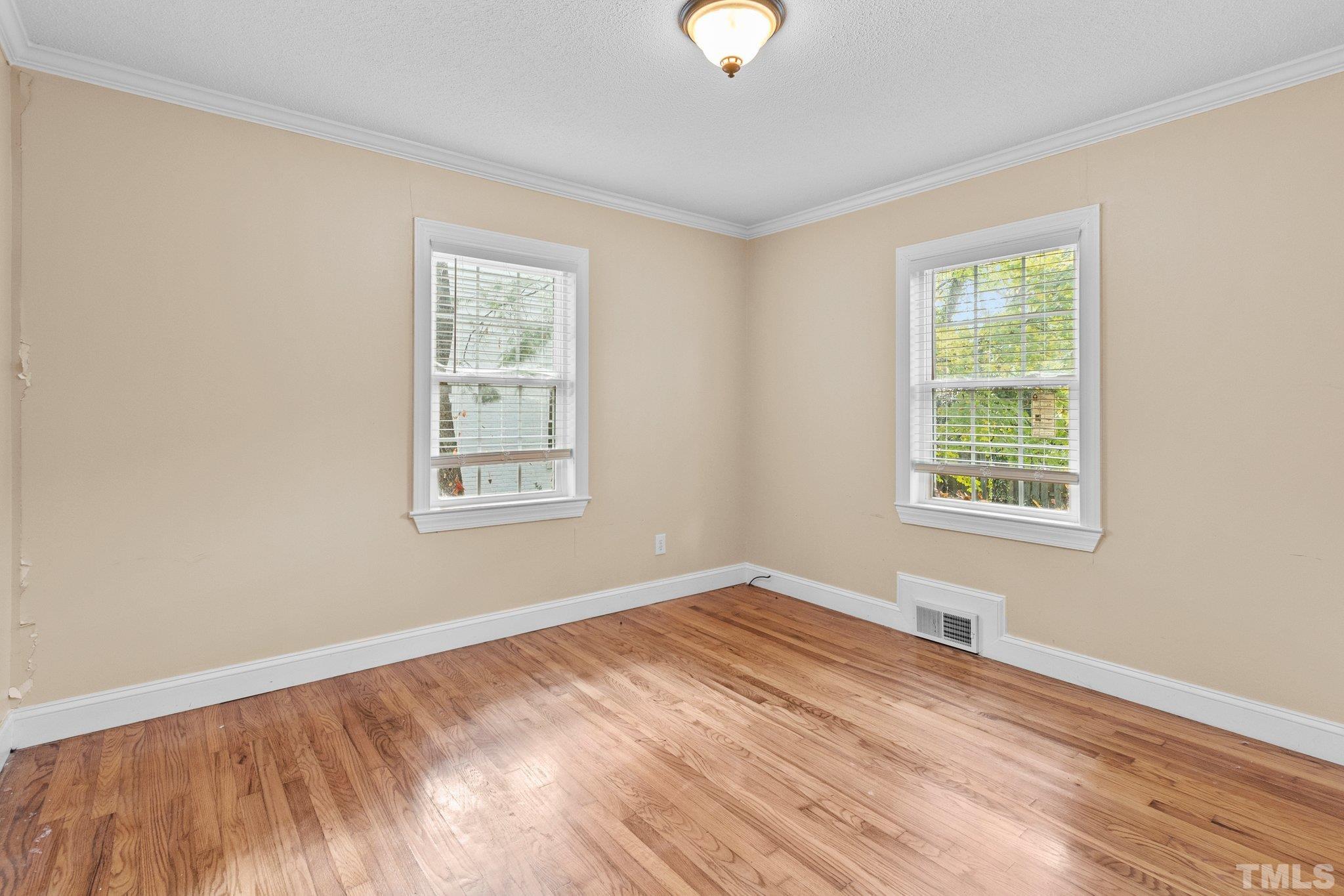 1713 Oberlin Road Raleigh, NC 27608 - Photo 17 of 34 a view of an empty room with wooden floor and a window