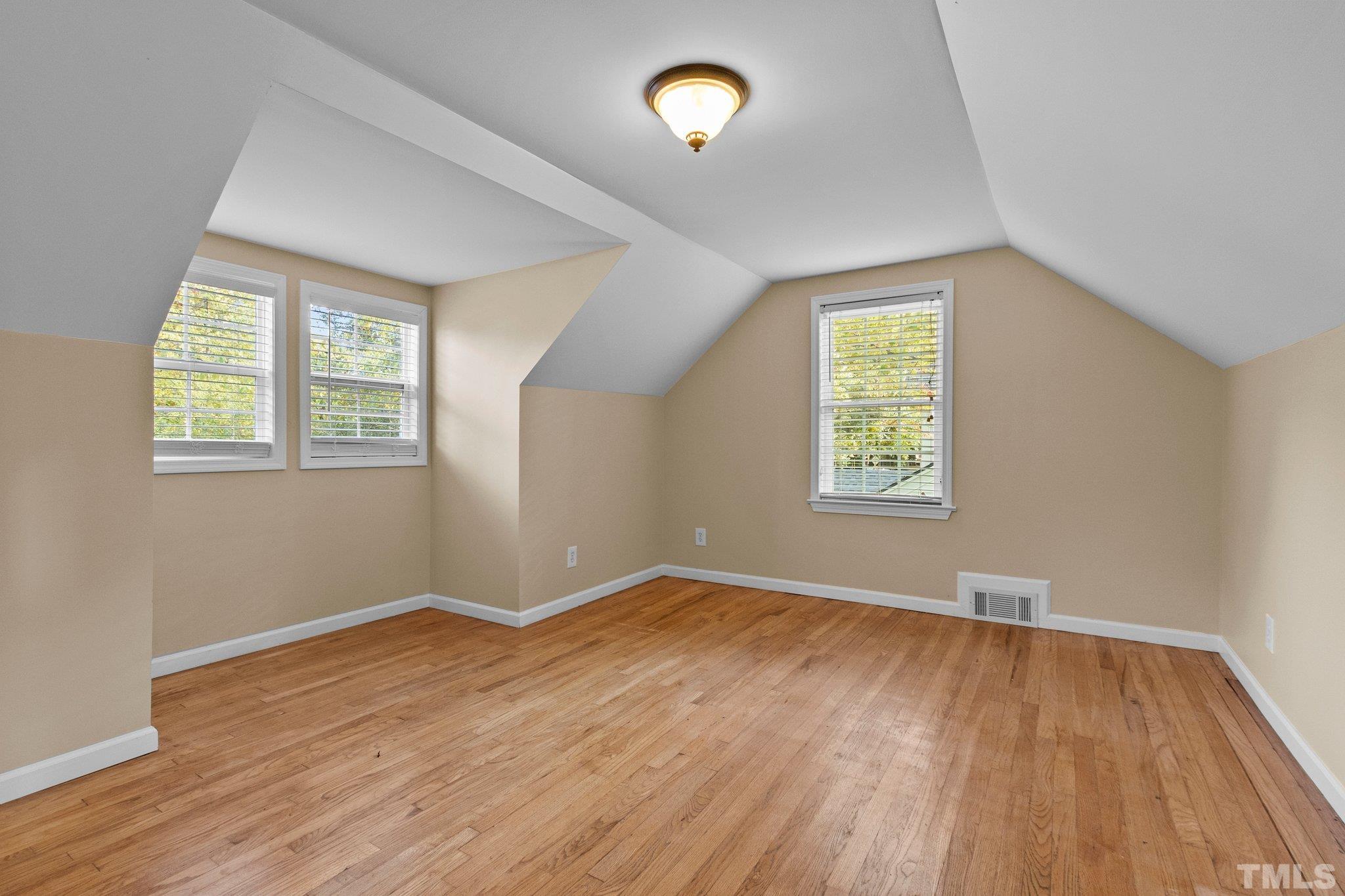 1713 Oberlin Road Raleigh, NC 27608 - Photo 21 of 34 an empty room with wooden floor and windows
