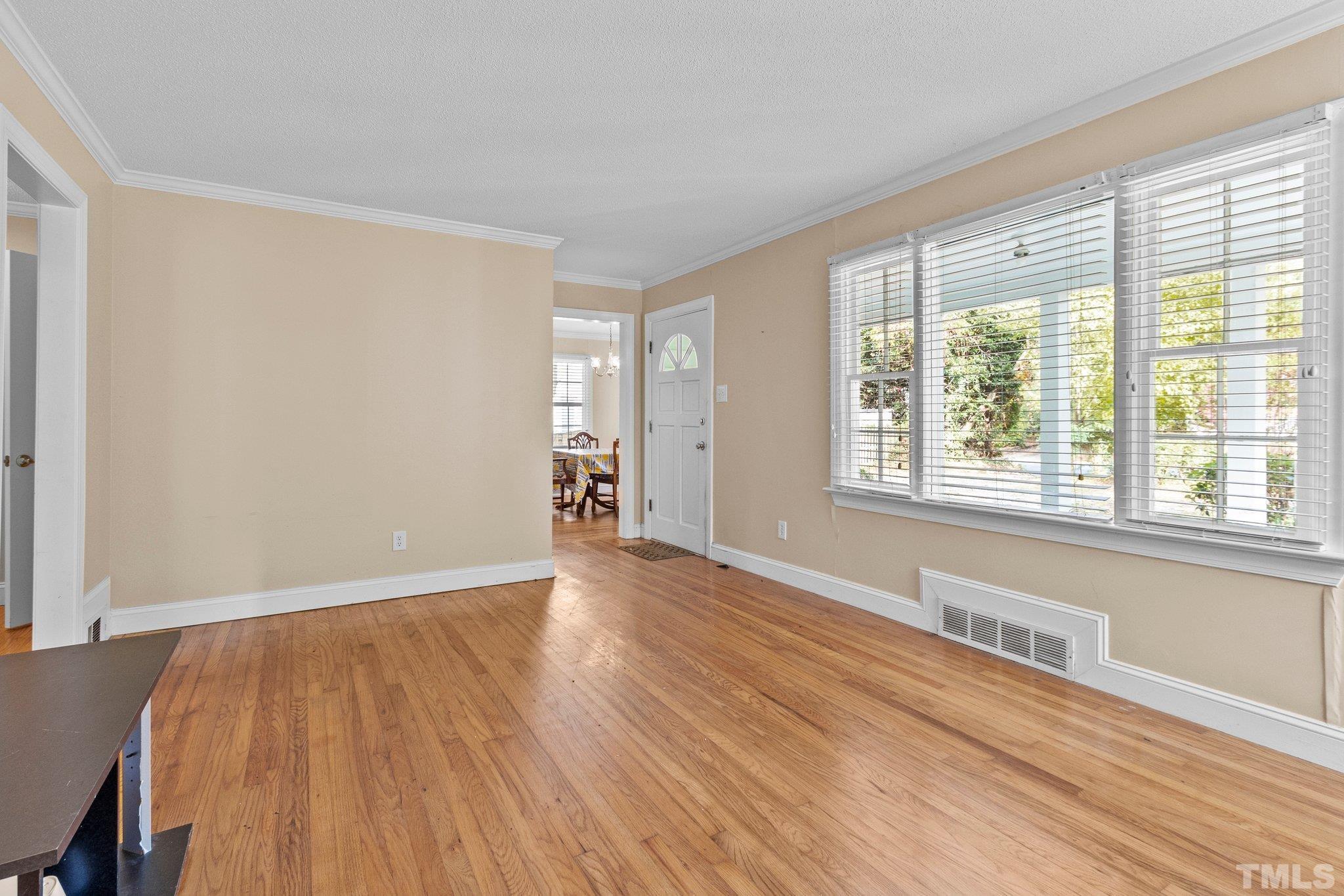 1713 Oberlin Road Raleigh, NC 27608 - Photo 6 of 34 a view of an empty room with wooden floor and a window
