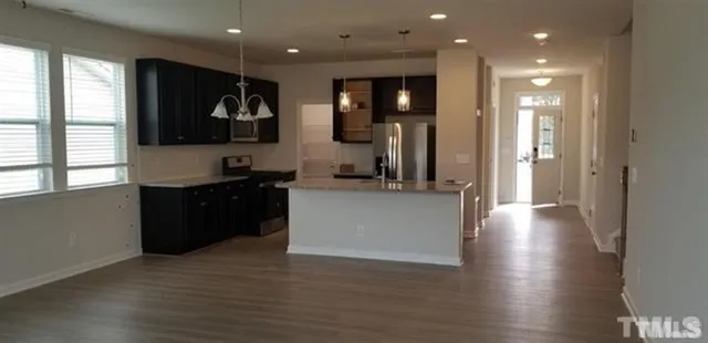 a view of a big room with wooden floor and windows