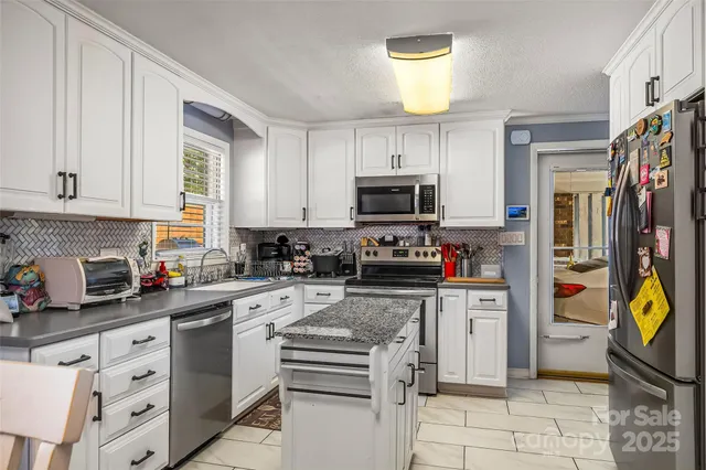 a kitchen with stainless steel appliances granite countertop a stove and a refrigerator