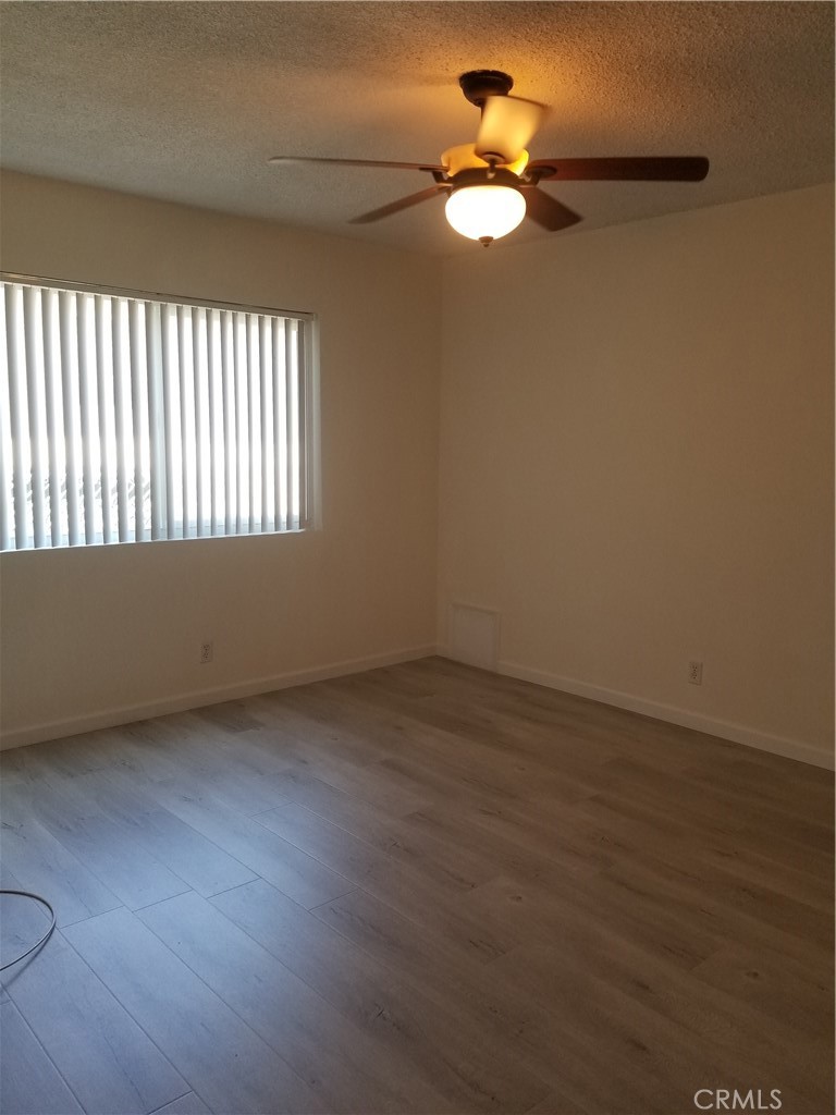 312 East Dryden Street, Unit 3 Glendale, CA 91207 - Photo 9 of 13 an empty room with wooden floor and a ceiling fan