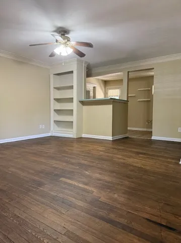a view of a room with wooden floor and ceiling fan